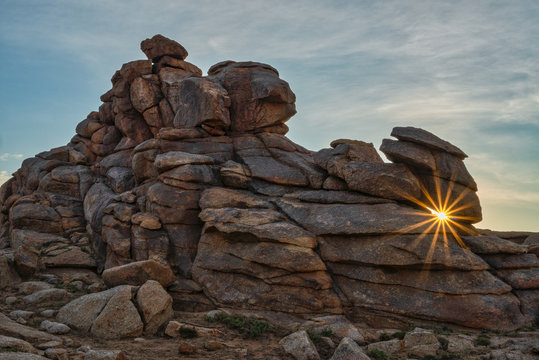 Sunburst through rocks at Baga Gazariin Chuluu, Mongolia