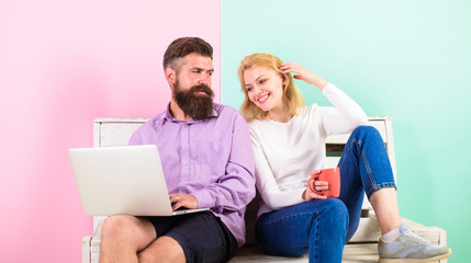 Couple with laptop going to watch movie. Family spend leisure together. Couple choosing comedy movie. Couple cheerful smiling faces like comedy movie. Family happy enjoy funny video film and laugh