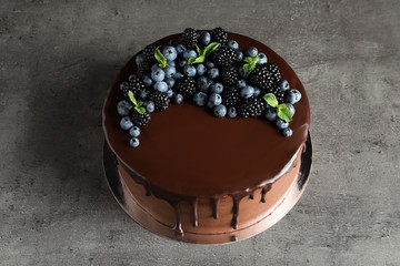 Fresh delicious homemade chocolate cake with berries on gray table