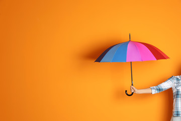 Woman holding beautiful umbrella on color background with space for design