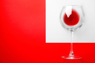 Glass with wine made of fresh ripe juicy grapes and space for text on color background, top view