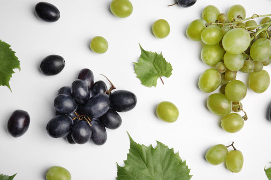 Fresh ripe juicy grapes and leaves on white background, top view