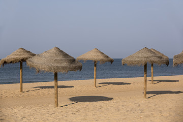Playa con sombrillas de paja.