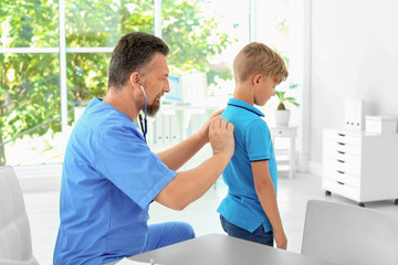 Obraz premium Male medical assistant examining child in clinic
