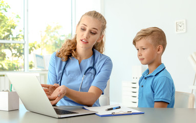 Female medical assistant explaining physical examination result to child in clinic