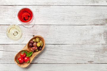White and rose wine glasses with olives and tomatoes
