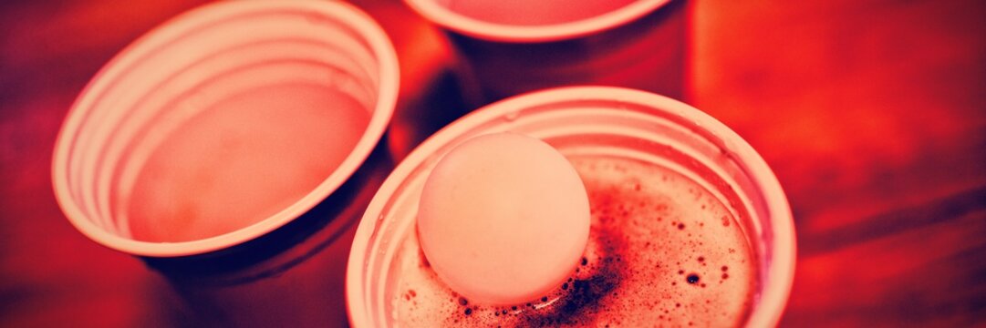 Close-up of pong ball on beer glass 