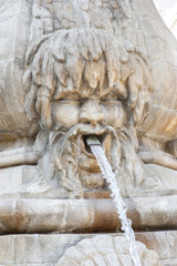 Face spouting water in a Baroque splashing fountain 