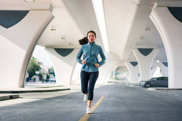 Girl running bellow the bridge in urban area
