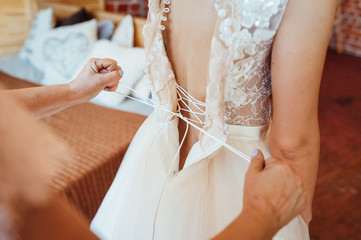 bridesmaids help to wear a wedding dress
