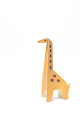 Fototapeta na wymiar One isolated origami giraffe stands on a white background
