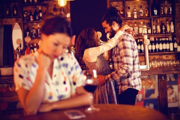 Jealous woman ignoring affectionate couple 