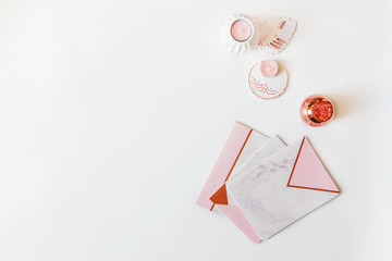 Flatlay of desk table. Workspace with modrn pink and marble notebooks and decorations on white background.