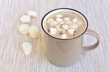 Mug of hot chocolate with marshmallows, warming sweet drink.