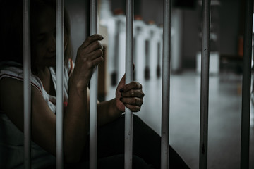 Obraz premium Portrait of woman desperate to catch the iron prison,prisoner concept,thailand people,Hope to be free.