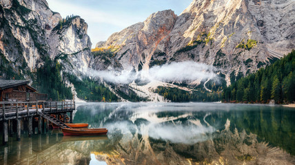 Panoramic view of Braies Lake with the hut and boats in Dolomites mountains and Seekofel in the morning, Sudtirol, Italy