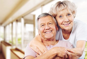 Happy senior couple smiling on background