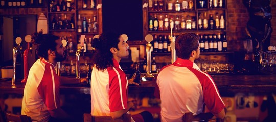 Group of male friends watching football match