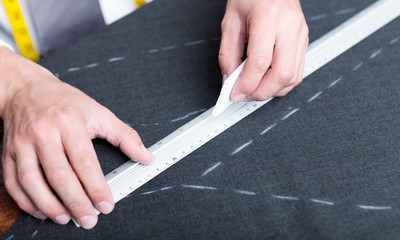 Dressmaker measuring tailor pattern  on background