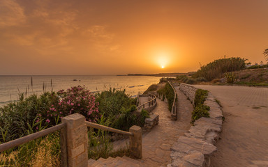 View of the beach of Fuente del Gallo with the lighthouse of Cape Roche in the background, in Conil, Andalucia. Spain