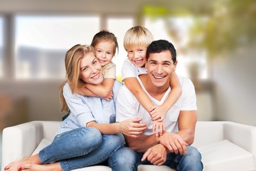 Beautiful smiling family sitting at sofa at home