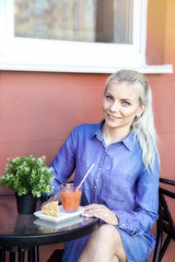 Beautiful woman sitting on the table in cafe. Outdoor