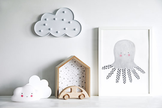 The modern scandinavian newborn baby room with mock up poster frame, wooden car and clouds. Minimalistic and cozy interior with white walls.