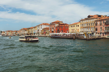 Fototapeta na wymiar Venetian channel view at the city of urban architecture, boats, buildings, pier, transport of Venice, free space