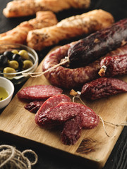 Salami sliced in rustic style. Salami sausage. Different sausages with cheese and olive.