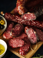 Salami sliced in rustic style. Salami sausage. Different sausages with olive