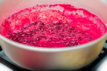 raspberry jam in the process of cooking the top view of the foam is formed