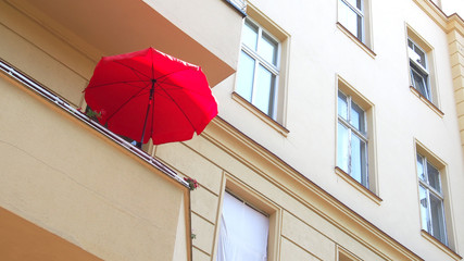 Sommer auf dem Balkon: Roter Sonnenschirm