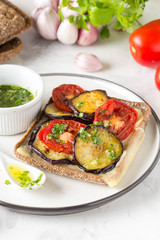 Open sandwich with eggplant, tomato, cheese and olive oil with greens and garlic. Delicious snack, homemade lunch, tasty food