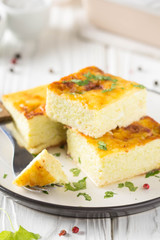 Fluffy omelet baked with zucchini, kids healthy Breakfast, delicious casserole. On white wooden background