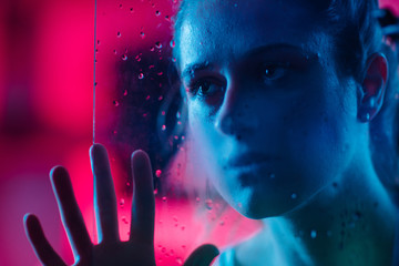 Girl looking through a glass with drops