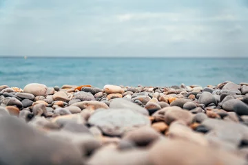 Fototapeten Pebble and stone rock beach with blue ocean 2 © Daniel