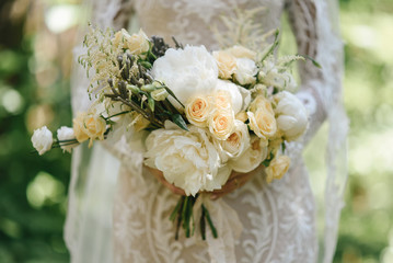 Beautiful wedding bouquet for the bride with peonies and white roses and eustoma