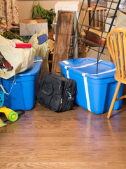 boxes, bins, bags, furniture piled up in living room. Stuff ready to move, be unpacked, or stored