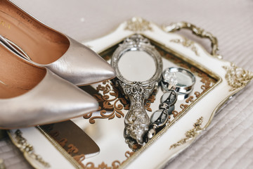 The details of the wedding day. Beautiful tray, mirror, magnifying glass for the bride and Golden shoes