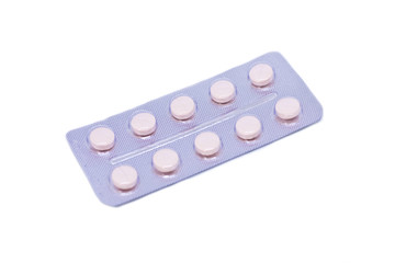 Pink pills in a package isolated on a white background