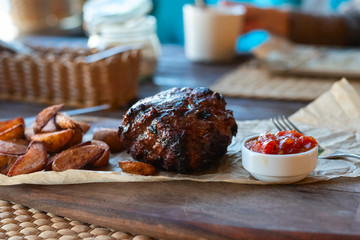Filet Mignon with fried potatoes and tomato sauce on a wooden Board with Cutlery
