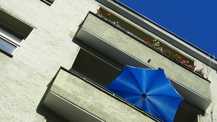 Naklejka premium Deutschland: Sommer auf dem Balkon, blauer Sonnenschirm, blauer Himmel