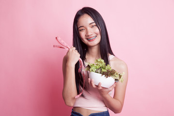 Healthy  Asian woman with measuring tape and salad.