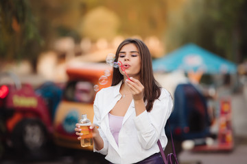 Happy adult girl blowing bubbles