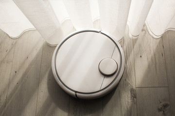 Robotic vacuum cleaner cleans the room from dust and debris, technological progress