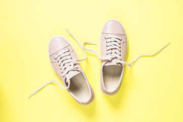 Woman fashion pink shoes on yellow background.