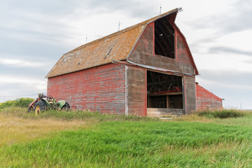 Obraz premium horizontal photo of an old red barn and tractor