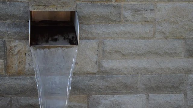 &Ouml;ffentliche Wasserquelle mit Edelstahl und Steinmauer
