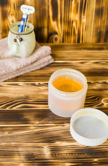 jar of sugar paste for sugaring, towels are on wood background (vertically)