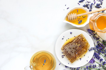Honey with lavender tea and honeycombs with freash flowers on white marble table. healthy food. top view